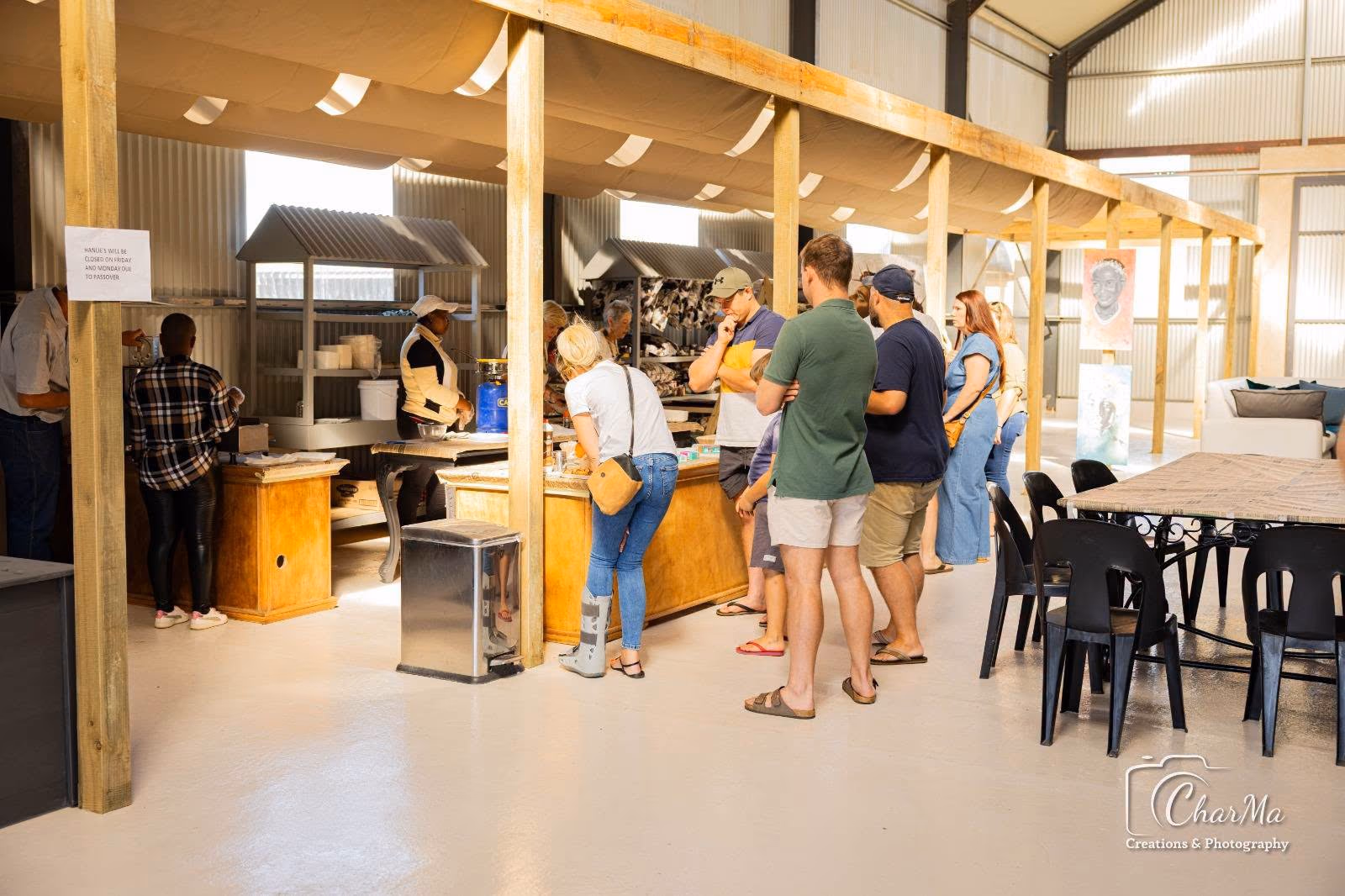 The airy indoor market hall with timber stalls and visitors browsing