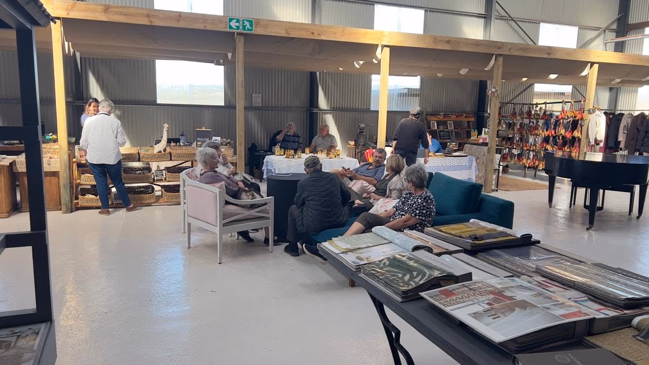The indoor market with stalls, lounge seating and visitors spending time together