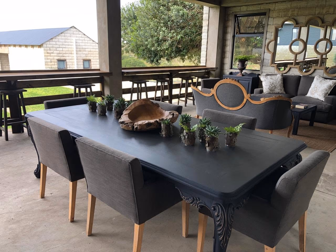 A large dining table and lounge arrangement on the covered veranda